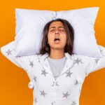 Woman sleeping with mouth open, illustrating a possible sleep apnea symptom in women